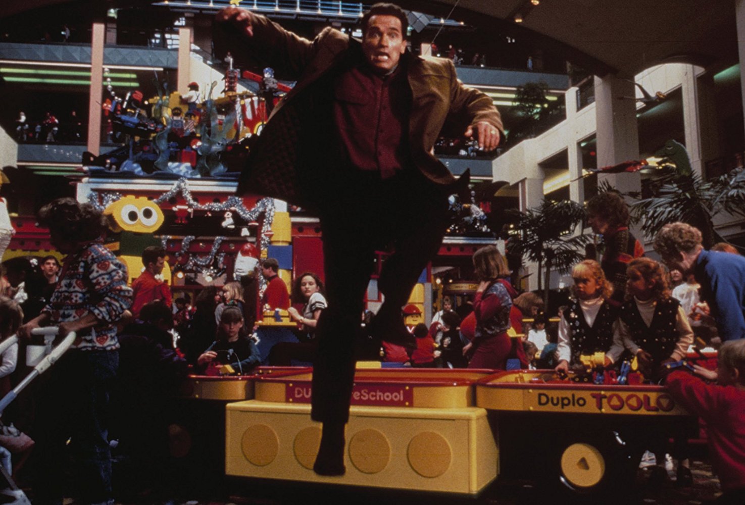 Arnold Schwarznegger paniqué dans un magasin de jouets, une scène du film "La course au jouet"