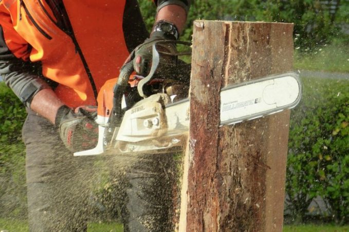 Une tronçonneuse entrain de couper un bout de bois