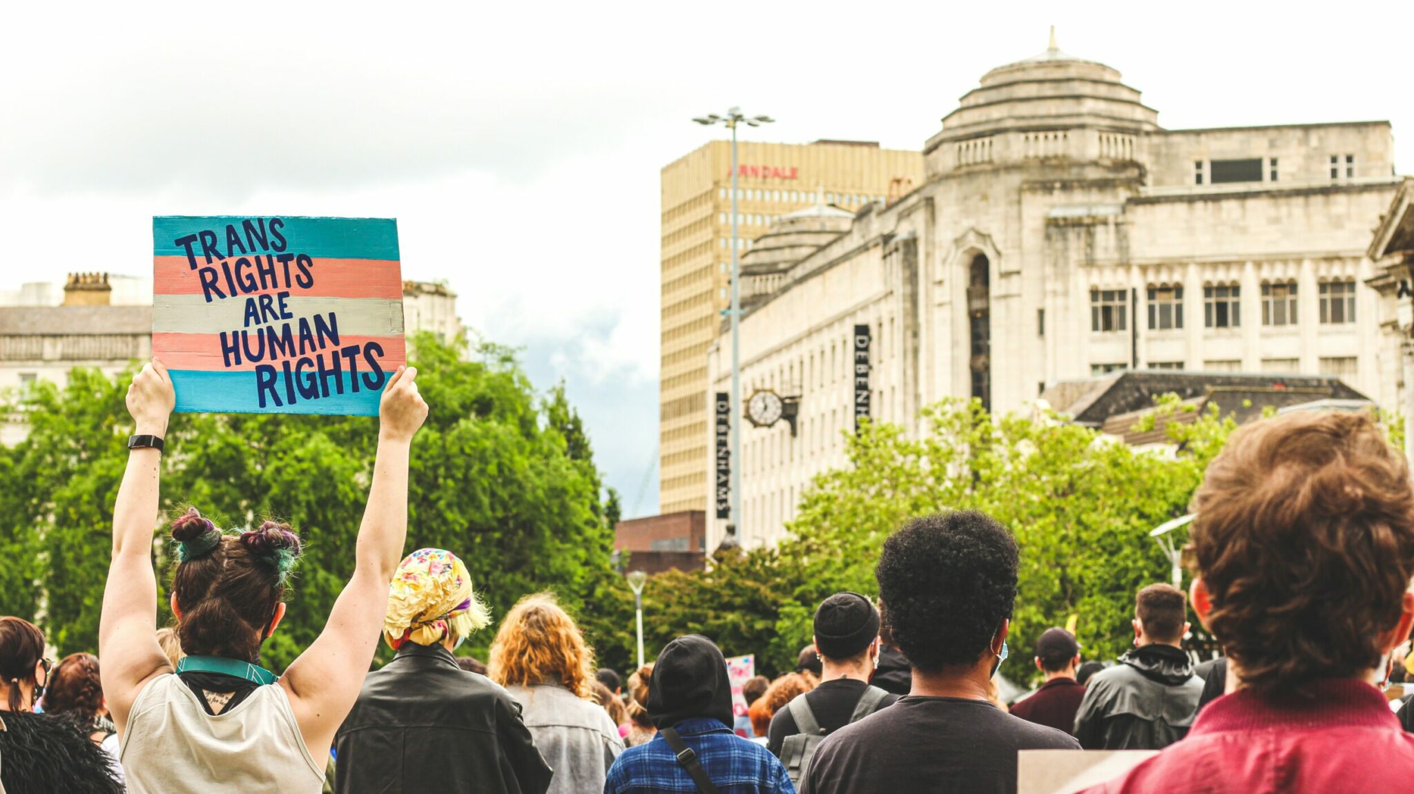 Une personne tenant un panneau « Les droits des personnes trans sont des droits humains » dans une manifestation. Une personne tenant un panneau « Les droits des personnes trans sont des droits humains » dans une manifestation.