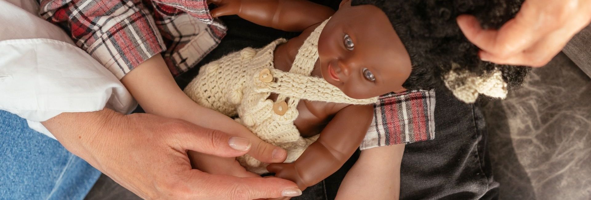 Enfant tenant une poupée Noire