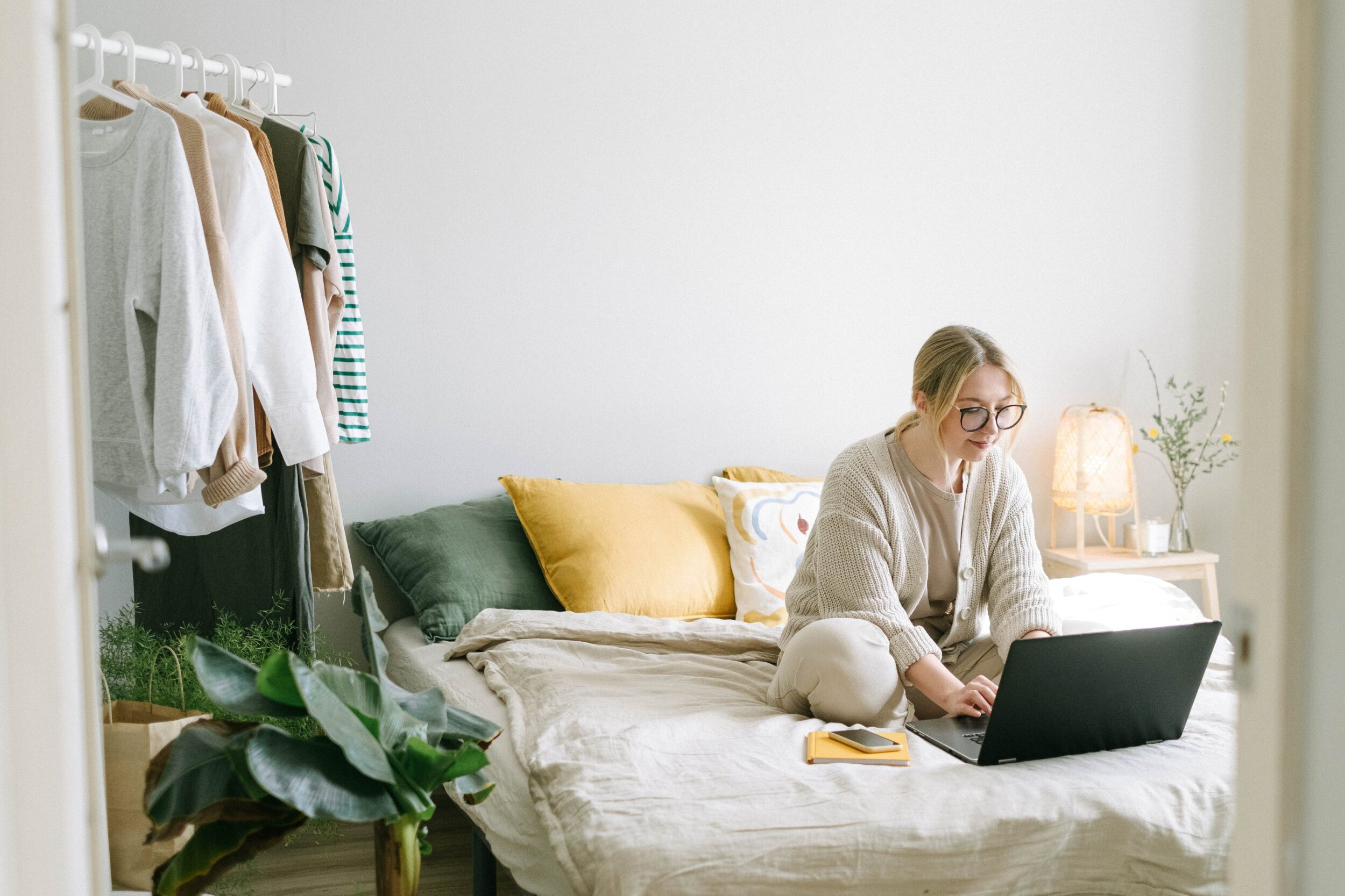 Une femme sur son lit avec son ordinateur.