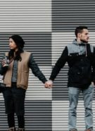 deux personnes qui se tiennent par la main mais ne se regardent pas