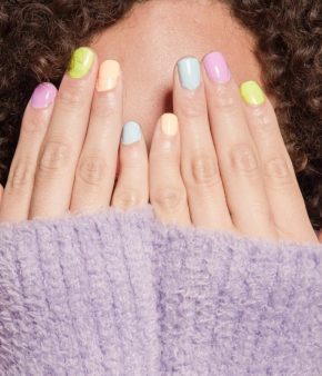 Jeune femme avec les ongles peints de différentes couleurs