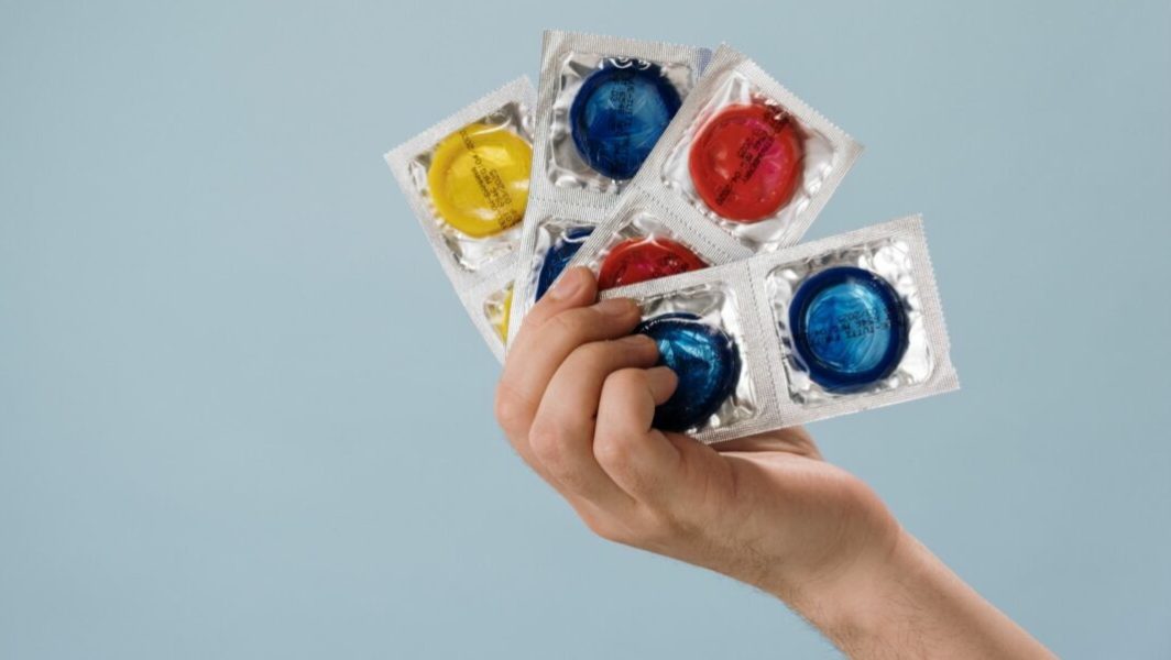 Personne tenant des préservatifs dans sa main