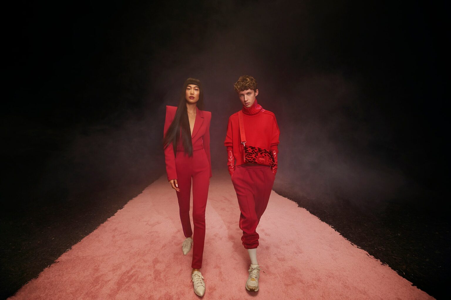 La mannequin chinoise Qin Shupei en combipantalon façon blazer ultra-épaulé et le chanteur australien Troye Sivan en pull, gants d'opéra en vinyle rouge et jogging trois bandes pour la collection #IvyHeart de Ivy Park x Adidas. La mannequin chinoise Qin Shupei en combipantalon façon blazer ultra-épaulé et le chanteur australien Troye Sivan en pull, gants d'opéra en vinyle rouge et jogging trois bandes pour la collection #IvyHeart de Ivy Park x Adidas.