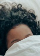 personne sous a couette, avec les cheveux qui depassent