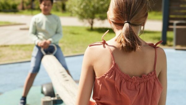 Un garçon et une fille sur une balançoire dans un parc pour enfants // Source : pexels-norma-mortenson