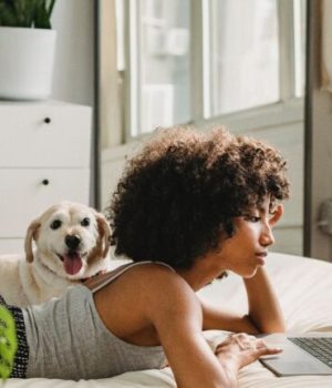 femme sur un lit devant un ordinateur