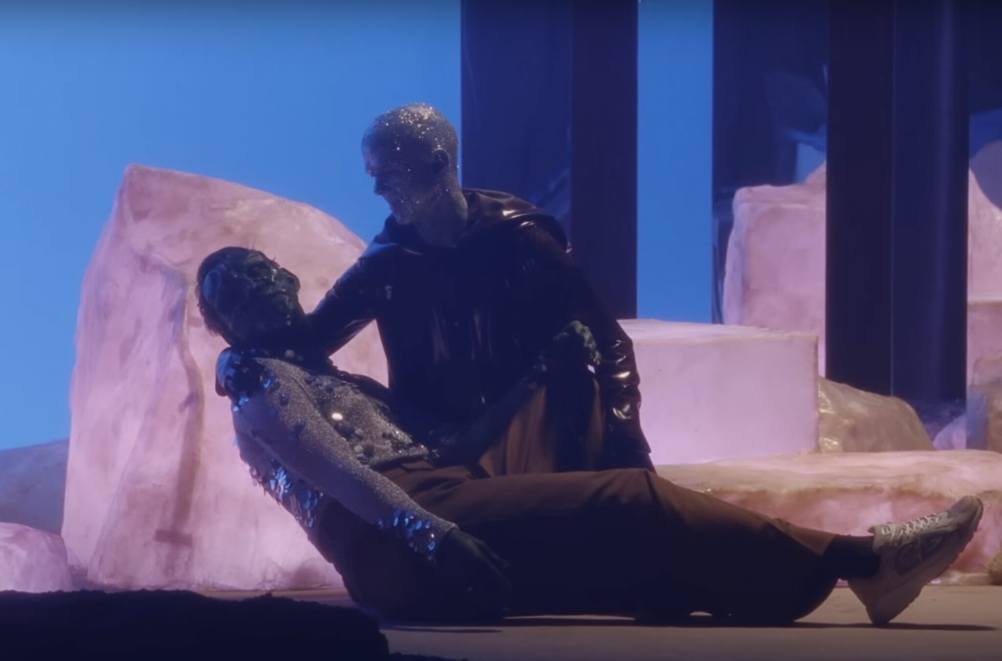 Dans le clip Hideous d'Oliver Sim, réalisé par Yann Gonzales, le chanteur et son ange-gardien Jimmy Somerville apparaissent transfigurés en monstres hideux et s'offrent une scène façon descente de croix qui en dit long sur la marginalisation des personnes vivant avec le VIH et la sérophobie. © Capture d'écran YouTube. Dans le clip Hideous d'Oliver Sim, réalisé par Yann Gonzales, le chanteur et son ange-gardien Jimmy Somerville apparaissent transfigurés en monstres hideux et s'offrent une scène façon descente de croix qui en dit long sur la marginalisation des personnes vivant avec le VIH et la sérophobie. © Capture d'écran YouTube.