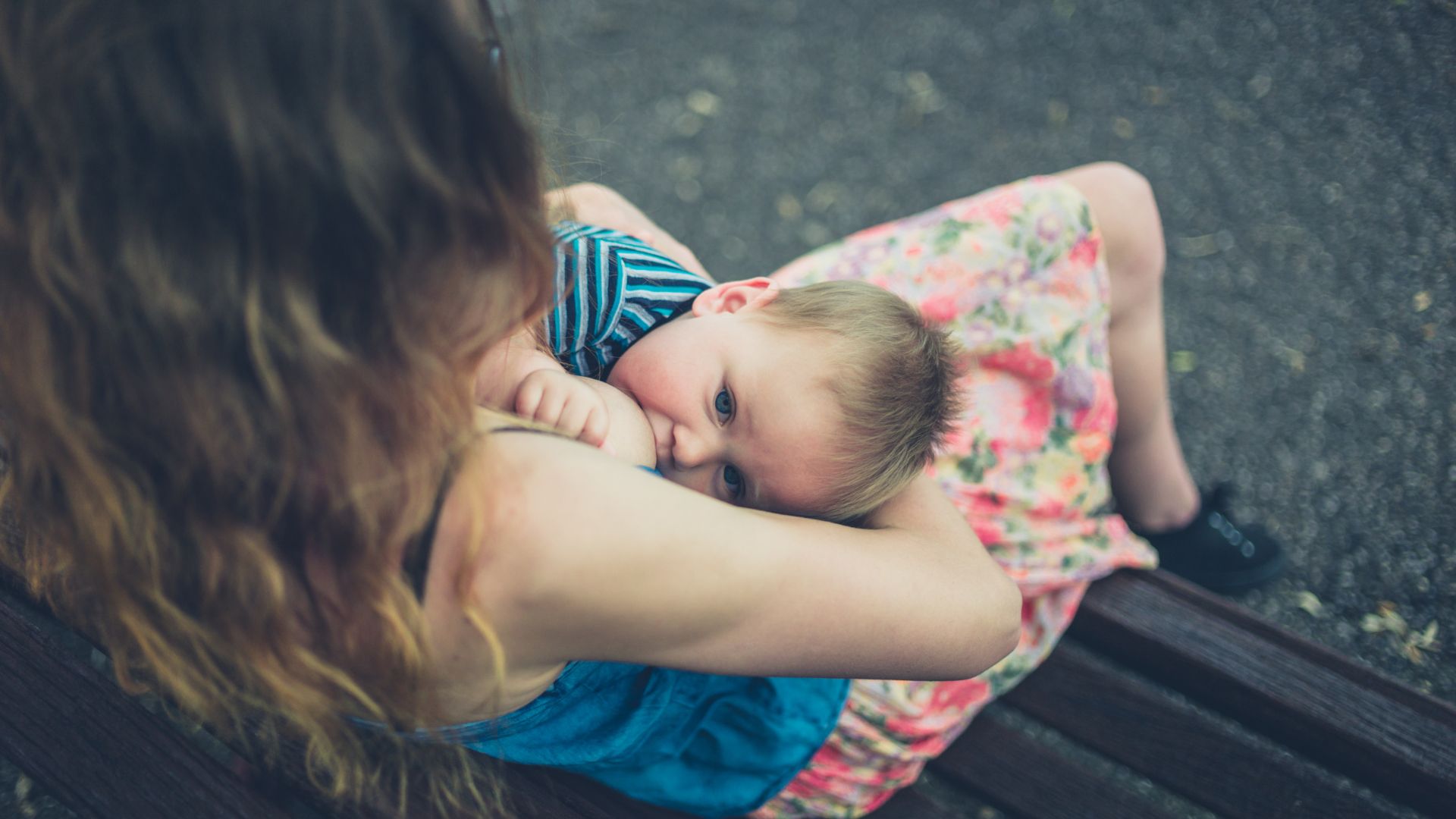 Mère qui donne le sein à son enfant sur un banc 