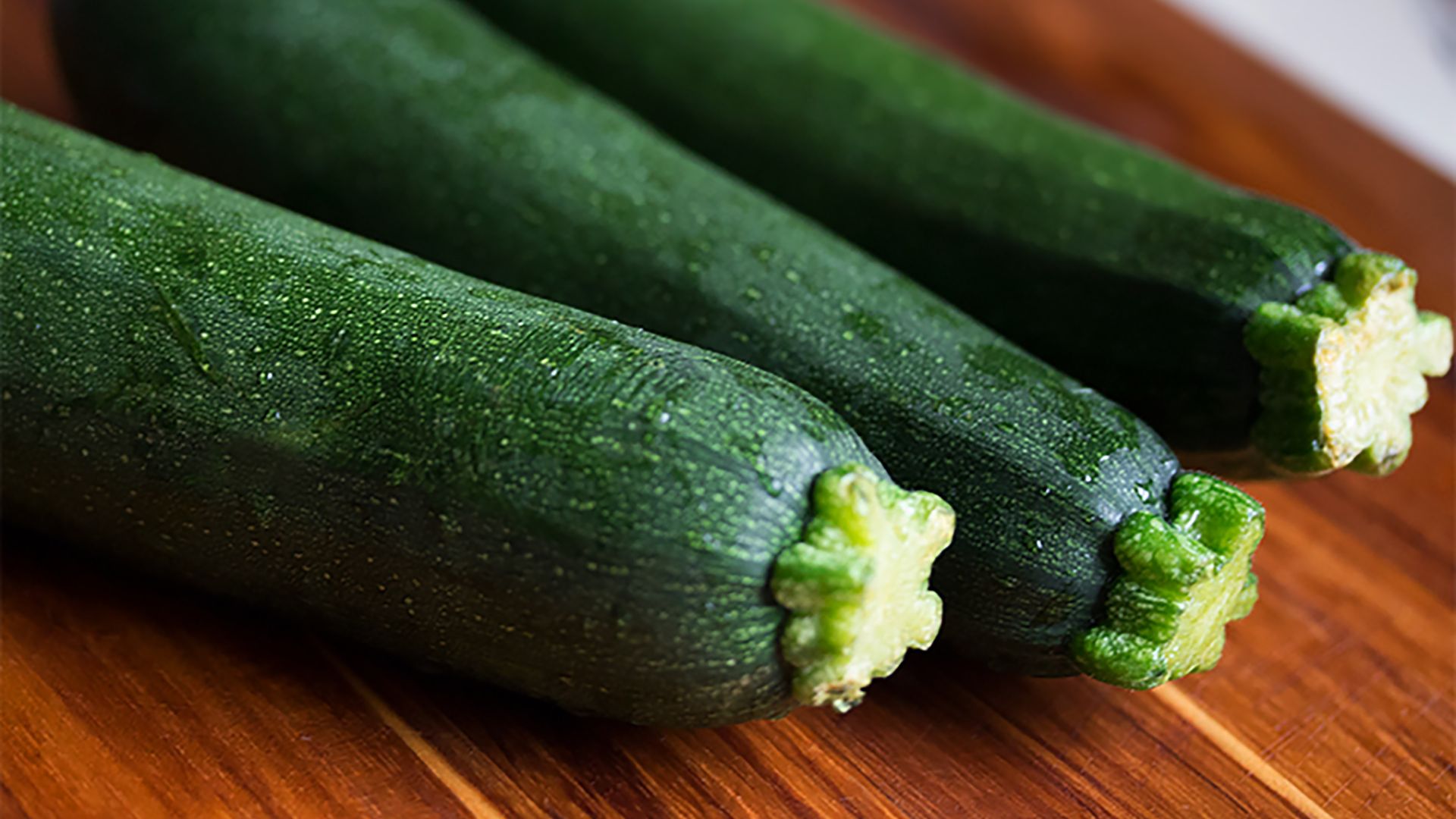 Des courgettes posées sur une planche