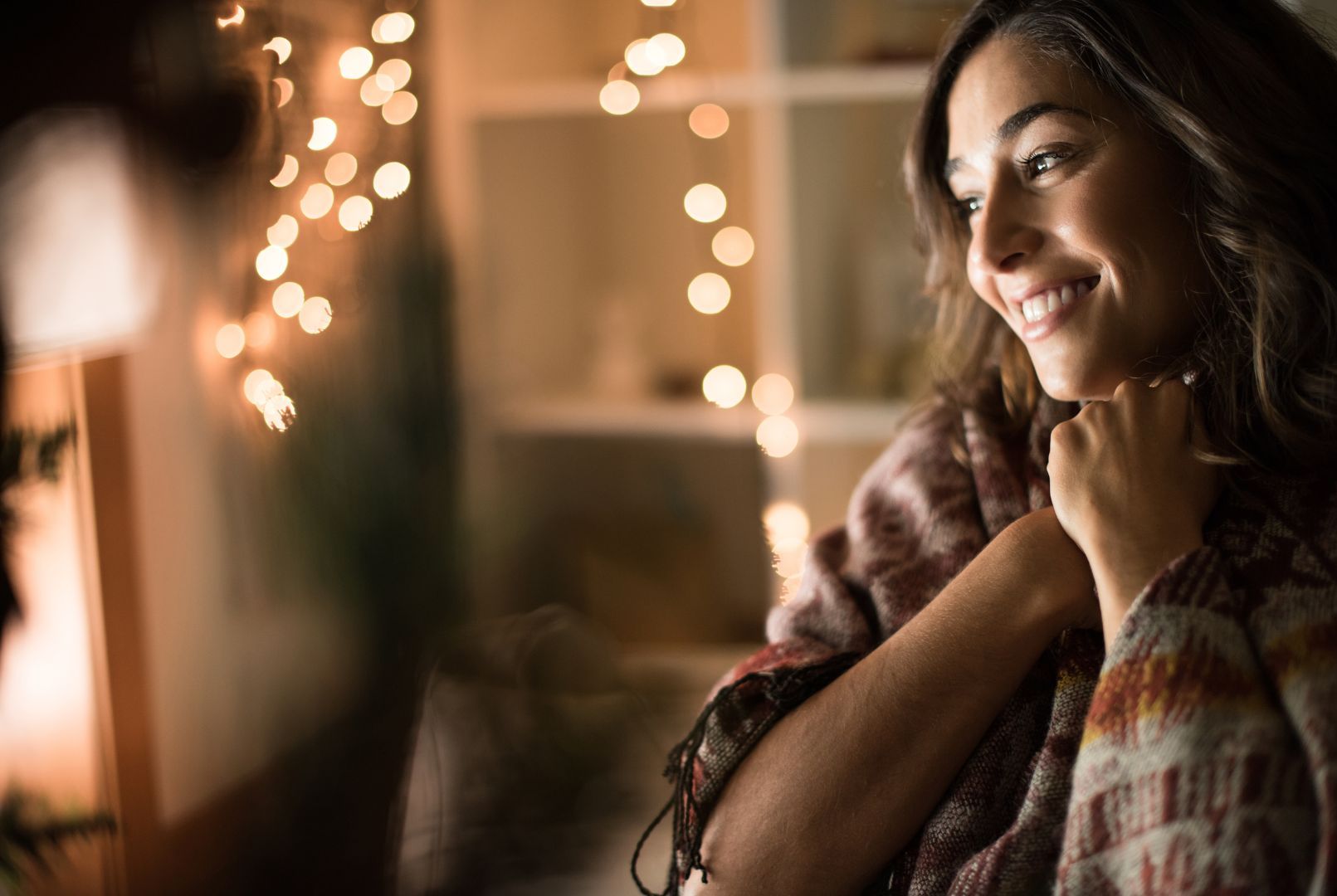 Une femme avec l’air gêné devant des guirlandes de Noel