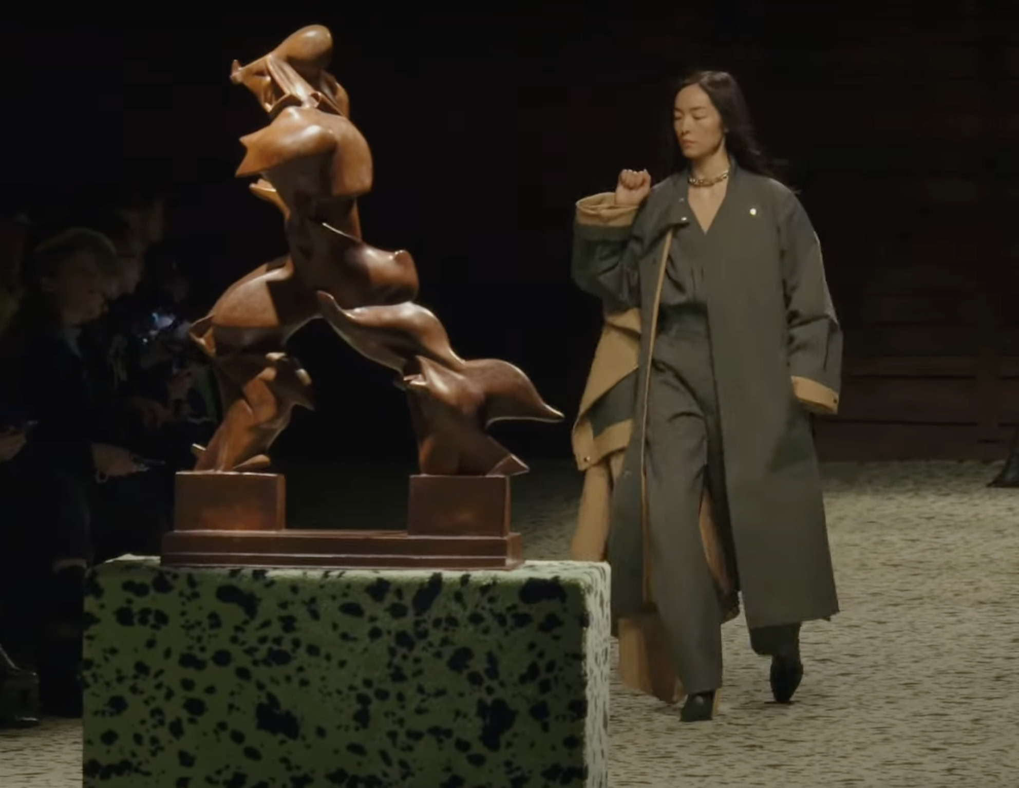 Une silhouette du défilé Bottega Veneta automne-hiver 2023-2024, derrière la célèbre sculpture L'Homme en mouvement (1913) de l'artiste futuriste italien Umberto Boccioni // Source : Capture d'écran YouTube