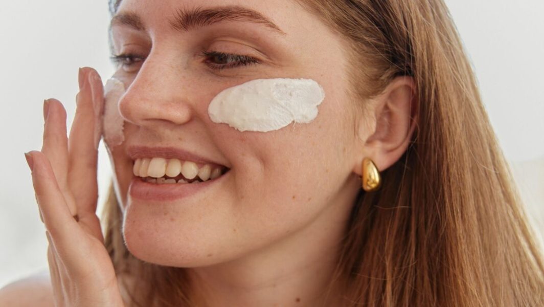 Jeune femme qui applique de la crème hydratante sur son visage. // Source : Darina Belonogova/Pexels