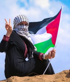 Une femme qui porte un keffieh palestinien sur son visage et le drapeau de la Palestine à la main // Source : hosny_salah de pixabay