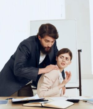 Un homme en train de toucher de façon inappropriée une femme sur son lieu de travail, ce qui peut être considéré comme une forme de violence sexiste // Source : Shotprime Un homme en train de toucher de façon inappropriée une femme sur son lieu de travail, ce qui peut être considéré comme une forme de violence sexiste // Source : Shotprime