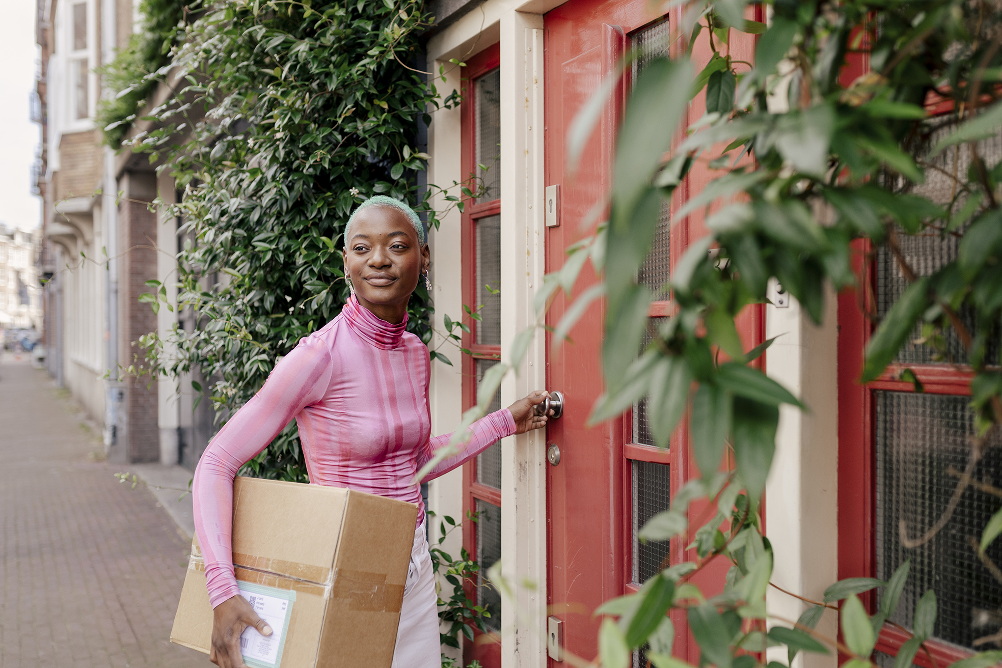 Une femme avec un carton de vêtement de seconde main sous le bras