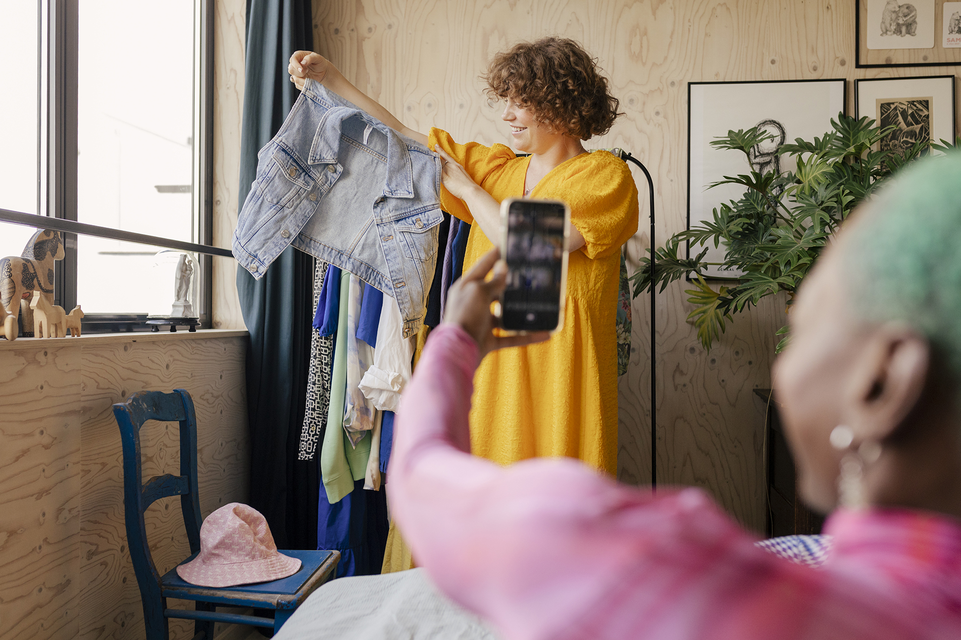 Une femme en train d’en photographier une autre pour vendre des vêtements