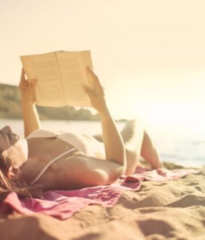 Femme en train de lire sur la plage en été // Source : PexelsAndrea Piacquadio