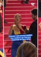 Une femme dans une robe aux couleurs du drapeau de l'Ukraine se recouvre de faux sang sur le tapis rouge du festival de Cannes 2023 // Source : Capture d'écran Twitter de BFM TV