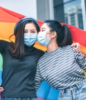 Deux femmes asiatiques qui portent fièrement le drapeau arc-en-ciel de la communauté LGBT // Source : Ezrin Nazan de Ezrin Nazan