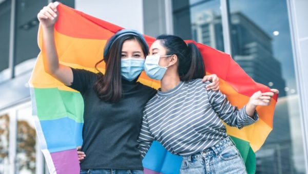 Deux femmes asiatiques qui portent fièrement le drapeau arc-en-ciel de la communauté LGBT // Source : Ezrin Nazan de Ezrin Nazan