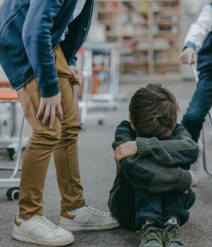 Un enfant victime de harcèlement scolaire, qui pleure assis par terre dans ses genoux // Source : Pexels / Mikhail Nilov