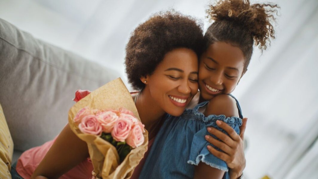 Une mère et sa fille avec un bouquet de roses à la main // Source : Aja Koska de Getty Images Signature