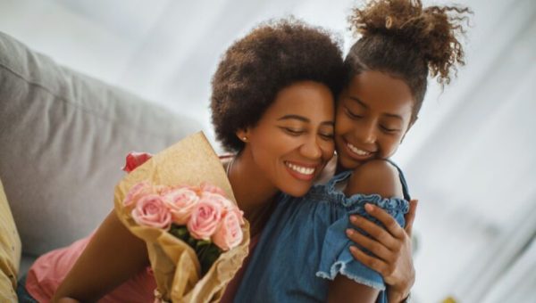 Une mère et sa fille avec un bouquet de roses à la main // Source : Aja Koska de Getty Images Signature