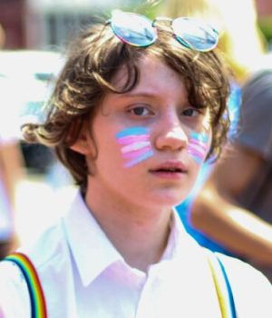Une personne maquillée du drapeau des transidentités lors d'une marche des fiertés (Pride) // Source : Rosemary Ketchum de Pexels