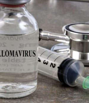 Une fiole en verre avec écrit papillomavirus dessus, ainsi qu'une aiguille de vaccination et un stéthoscope en arrière-plan // Source : Richard Villalonundefined undefined de Getty Images