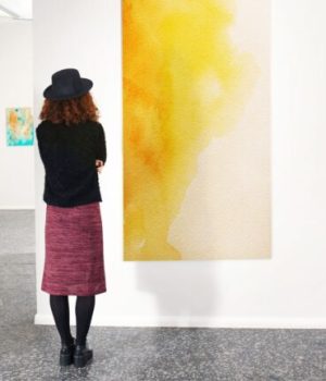 Une femme admire un tableau dans une galerie d'art // Source : pixelshot