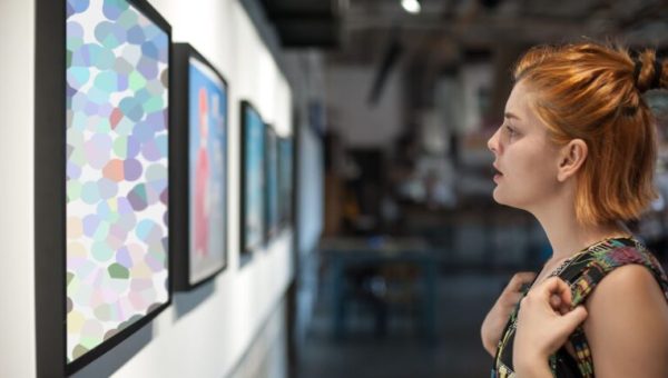 Une femme admire un tableau dans une galerie d'art contemporain // Source : guruXOOX de Getty Images