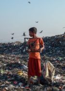 Un enfant au milieu d'une décharge à ciel ouvert pleine de pollution textile // Source :  Muhammad Amdad Hossain de Pexels