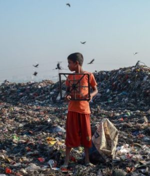 Un enfant au milieu d'une décharge à ciel ouvert pleine de pollution textile // Source :  Muhammad Amdad Hossain de Pexels