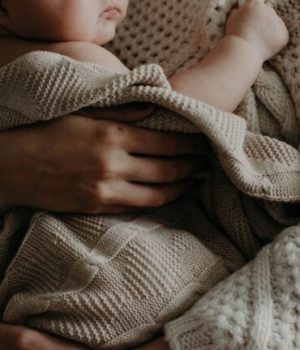 Un bébé dans les bras de son parent, Kristina Paukshtite de Pexels // Source : Kristina Paukshtite de Pexels