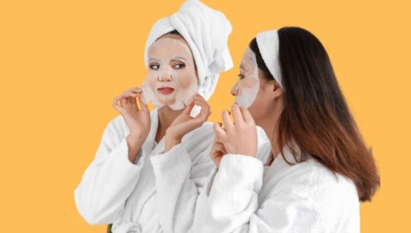 Deux femmes en peignoir de bain en train de s'appliquer un masque en tissu sur le visage // Source : Pixelshot
