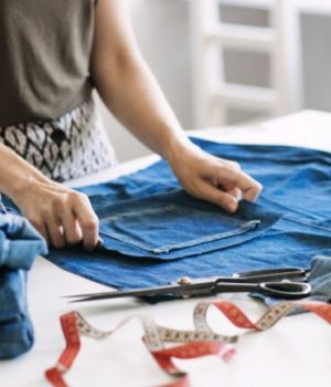 Une femme en train de réparer un jean // Source : irynakhabliuk via Canva