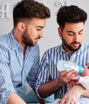 Un couple d'homme en train de s'occuper de leur bébé né par Gestation pour Autrui // Source : alvarostock