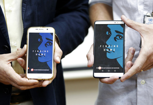 Representative of the United Nations High Commissioner for Refugees (UNHCR) Malaysia Richard Towle, left, and Executive Creative Director of GREY Malaysia, Graham Drew, right, shows the application "Finding Home" on their phones during a launch at the UNHCR headquarters in Kuala Lumpur, Malaysia, Tuesday, April 25, 2017. The refugee agency and the Malaysian firm have launched the application aimed at raising public awareness and empathy about the worldwide struggle of refugees. (AP Photo/Daniel Chan)
