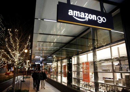 People walk by the Amazon Go brick-and-mortar grocery store without lines or checkout counters, in Seattle Washington