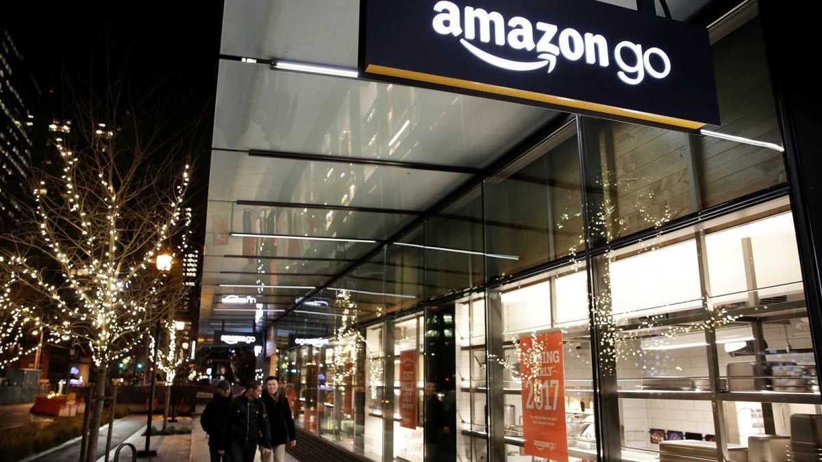 People walk by the Amazon Go brick-and-mortar grocery store without lines or checkout counters, in Seattle Washington