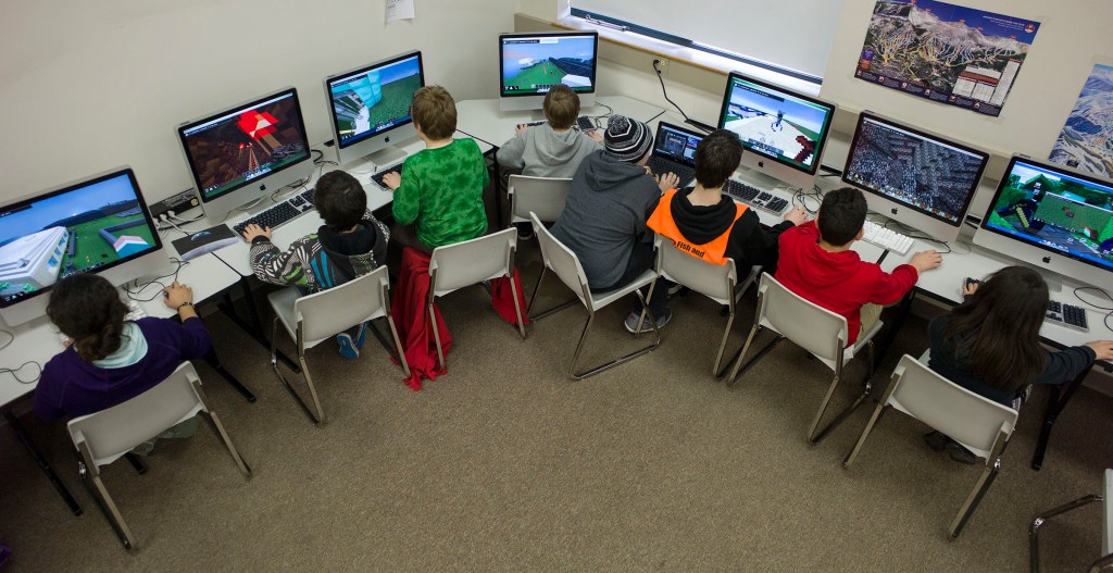 Sixth-graders at Dzantik'i Heeni Middle School work on the Mindcraft mazes during their technology class in Juneau, Alaska, on Friday, March 6, 2015.  Rather than fight the electronic glue, some educators are embracing children tech-obsession and finding ways to incorporate computer games into the classroom. None has been more popular than Minecraft. (AP Photo/The Juneau Empire, Michael Penn )