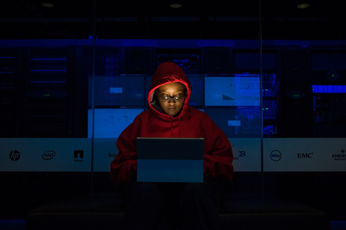 Une femme qui ne pirate probablement pas un réseau WiFi mais qui a une capuche de hackeuse. // Source : WoC In Tech