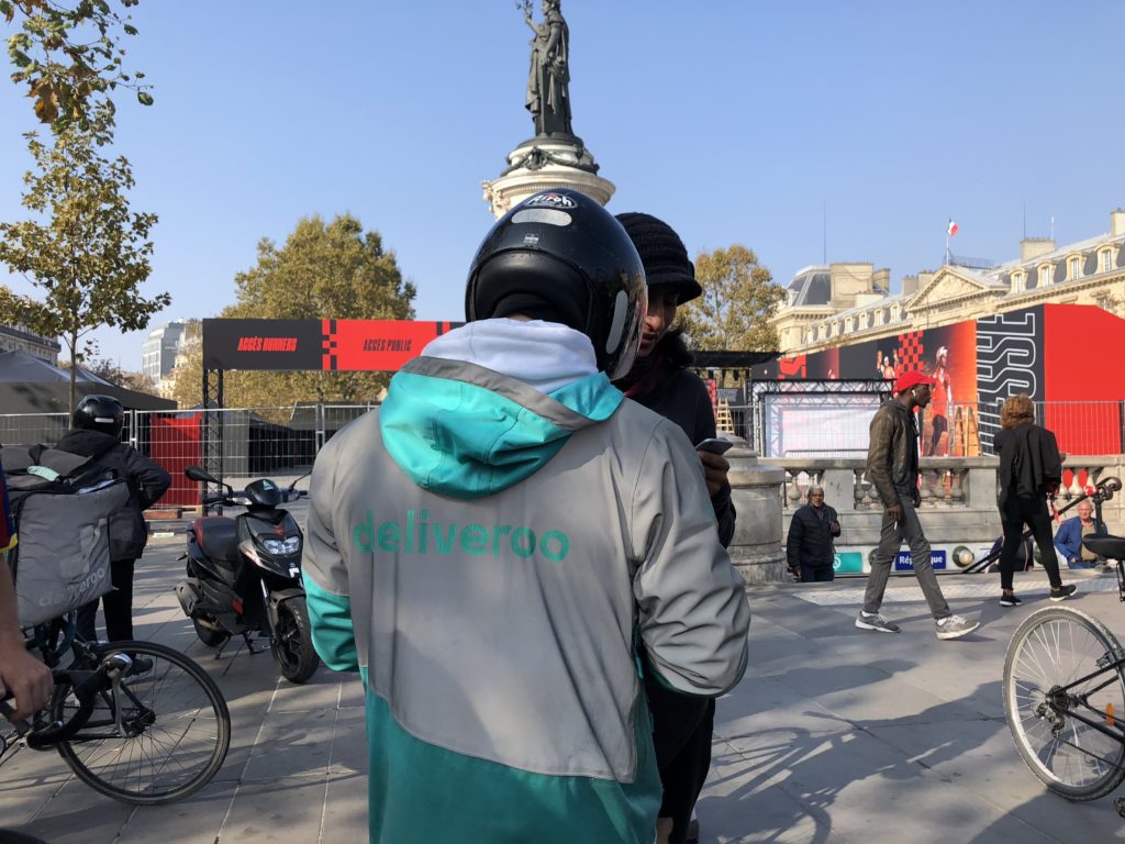 En tenue de travail, une trentaine de livreurs se sont réunis, place de la République à Paris, pour revendiquer une hausse de leurs revenus. // Source : Numerama