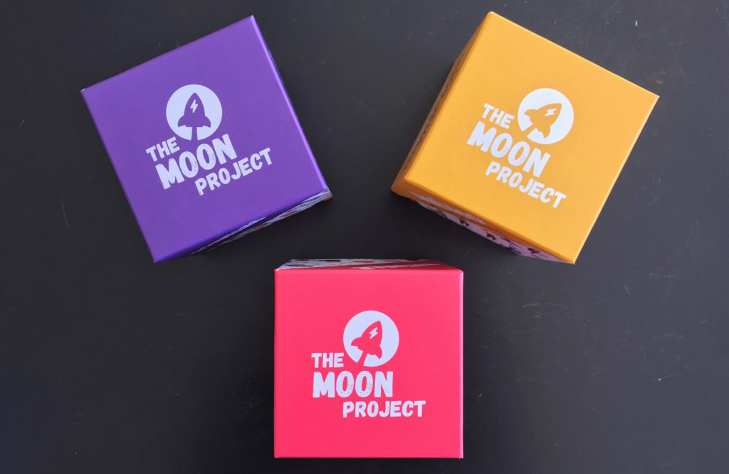 Trois jeux de cartes présentés dans une boîte cubique en carton. // Source : Nelly Lesage pour Numerama