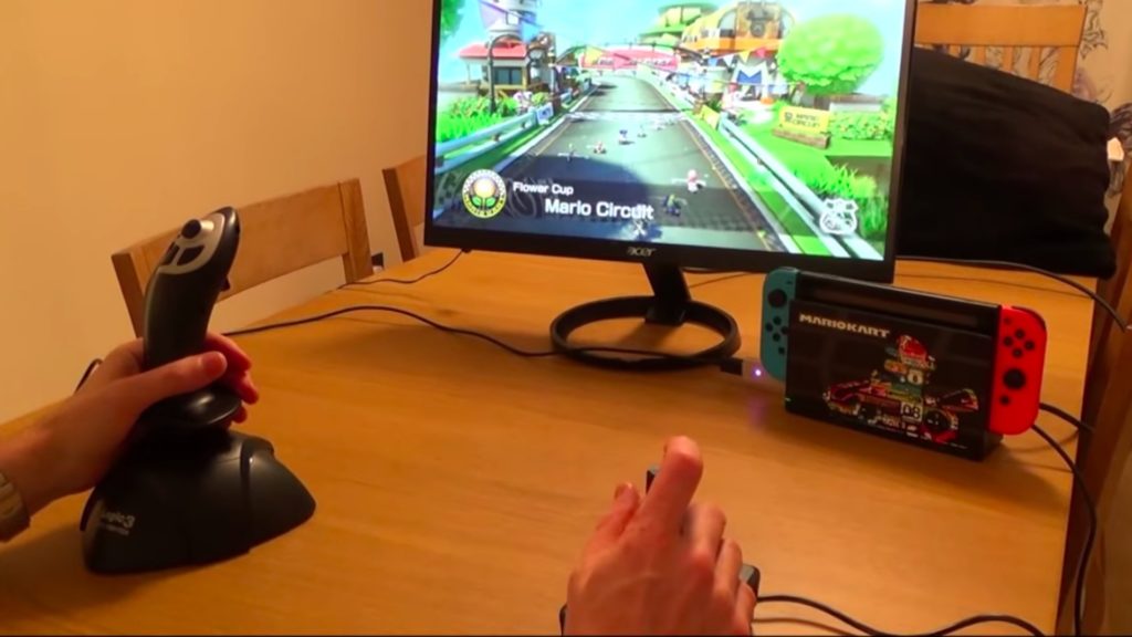 Le set up de My Mate VINCE pour Mario Kart 8 sur Switch, avec deux joysticks et la manette adaptative de Microsoft aux pieds. // Source : Youtube