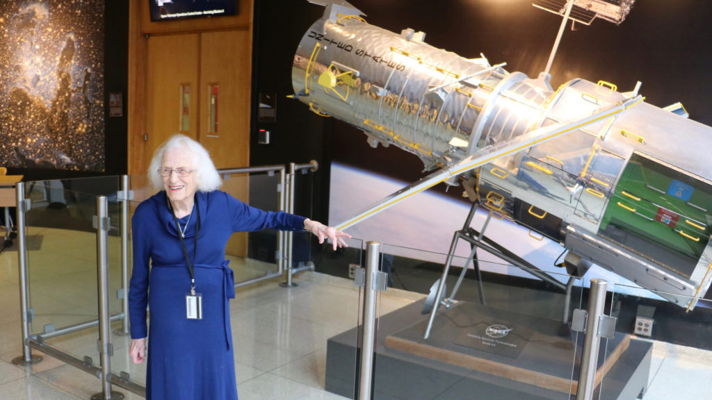 Nancy Grace Roman en mars 2017 au côté d'une reproduction du télescope Hubble. // Source : Flickr/CC/Nasa Hubble Space Telescope (photo recadrée)