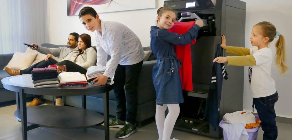 Image rare d'enfants heureux de plier des vêtements pendant que leurs parents regardent Netflix au calme. // Source : Foldimate