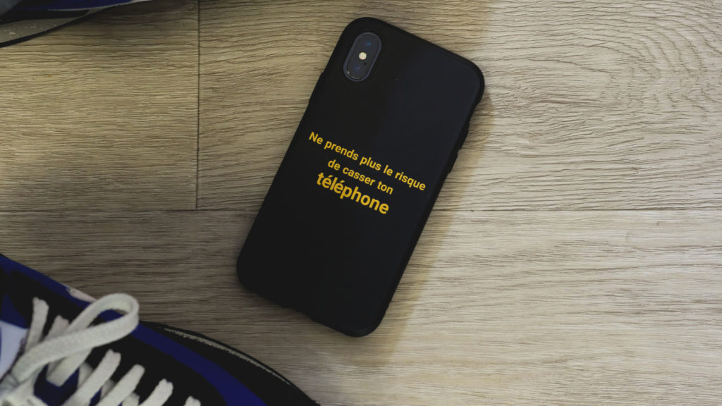 Une iPhone X avec une coque au texte personnalisé.